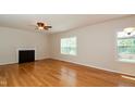 Bright living room featuring hardwood floors, fireplace, and large windows at 216 Stoney Dr, Durham, NC 27703