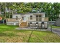 Single-story home with deck, fenced yard, and storage shed at 113 Winnebago Loop, Louisburg, NC 27549