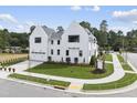 White two-story home with attached garage and landscaped yard at 3300 Founding Place, Raleigh, NC 27612