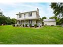Two-story farmhouse with wraparound porch and large yard at 8401 Mitchell Mill Rd, Zebulon, NC 27597