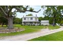 Farmhouse with wraparound porch, large tree, and stone accents at 8401 Mitchell Mill Rd, Zebulon, NC 27597