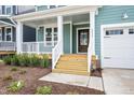 Front porch with wooden stairs and white railing at 2332 Whitewing Ln # 2451, Wendell, NC 27591