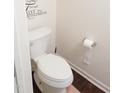 Small bathroom with white toilet and fixtures, and a decorative wall accent at 509 Hallie Long Ln, Burlington, NC 27217