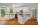 Galley kitchen with granite countertops and white cabinets at 7700 Pinecrest Rd, Raleigh, NC 27613