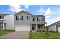 Two-story house with gray siding, white garage door and landscaping at 1716 Post Oak Dr, Haw River, NC 27258