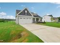 Two-story house with a two-car garage and landscaped yard at 129 Colby Farm Dr, Kenly, NC 27542