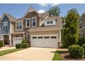 Two-story townhome with stone and siding accents, two-car garage, and landscaped front yard at 622 Chronicle Dr, Cary, NC 27513