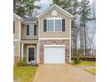 Tan two-story townhome with a white garage door and stone accents at 2833 Egert Dr, Haw River, NC 27258