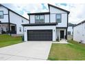 Two-story home with a black garage door and white brick exterior at 312 Sustainable Way, Raleigh, NC 27610