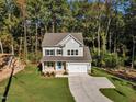 Two-story house with gray siding and a two-car garage, nestled in the woods at 900 Sw Maynard Rd, Cary, NC 27511
