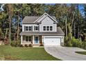 Two-story house with gray siding, stone accents, and a two-car garage at 900 Sw Maynard Rd, Cary, NC 27511