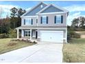 Two story house with gray siding, brick accents, and a two car garage at 116 Bristow Ct # 49, Four Oaks, NC 27524