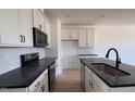 Modern kitchen with white cabinets, black countertops and stainless steel appliances at 1633 Wendell Valley Blvd, Wendell, NC 27591