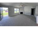 Spacious living room with gray walls, carpeted floor, and a corner fireplace at 138 Lotus Ave, Smithfield, NC 27577