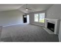 Bright living room featuring gray walls, carpeted floors, and a fireplace at 138 Lotus Ave, Smithfield, NC 27577
