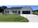 One-story house with gray siding, a dark gray door, and a two-car garage at 138 Lotus Ave, Smithfield, NC 27577