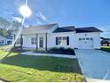 White house with front porch, black door, and two-car garage at 36 Kevior Ave, Four Oaks, NC 27524