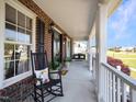 Inviting front porch with rocking chairs and a swing, perfect for relaxing at 107 Knottingham Ct, Dunn, NC 28334