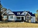 One-story house with white siding, stone accents, and dark roof at 225 Whistlers Cv, Louisburg, NC 27549