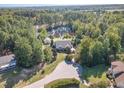 Home with pond and circular driveway, surrounded by trees at 3313 Overhead Ct, Willow Springs, NC 27592