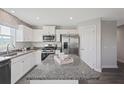 Modern kitchen with white cabinets, granite countertops, and stainless steel appliances at 79 Lawnview Ct, Fuquay Varina, NC 27526