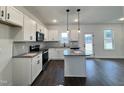 Spacious kitchen with white cabinets, granite island, and dark hardwood floors at 149 Greenview St, Clayton, NC 27520