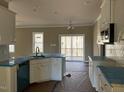 Bright kitchen with white cabinets, island, and sliding glass doors to a deck at 51 Dark Night Ln, Zebulon, NC 27597