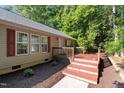 House exterior featuring tan siding, red deck, and walkway leading to entrance at 126 Yuma Dr, Louisburg, NC 27549