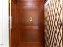Elegant wood-paneled elevator with brass gate, adding a touch of class at 50211 Manly, Chapel Hill, NC 27517
