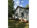 Side view of a modest white house with a brick foundation and AC unit at 4285 Belltown Rd, Oxford, NC 27565