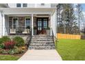 Front entry with stone steps, wooden door, and landscaping at 600 Darian Woods Drive,, Holly Springs, NC 27540