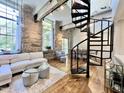 Open concept living space with a spiral staircase and exposed beams at 1500 River Mill Dr # 310, Wake Forest, NC 27587