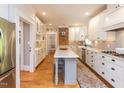Modern kitchen with white cabinets, a large island and hardwood floors at 209 E Whitaker Mill Rd, Raleigh, NC 27608