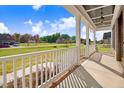 Covered front porch with white railing overlooking a landscaped neighborhood at 46 Otter Hole Dr, Princeton, NC 27569