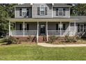 Gray house with a covered porch and brick steps at 1001 Yopon Ct, Raleigh, NC 27603