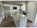 Modern kitchen with large island and white cabinets at 749 Sherrill Farm Dr, Benson, NC 27504