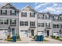 Three-story townhouses with gray siding and two-car garages at 1109 Pale Moss Dr, Durham, NC 27704