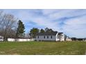 White house exterior with a large backyard at 15 Bella Ln, Zebulon, NC 27597