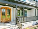 Inviting front porch with double wooden doors and black railings at 2804 Jack Mitchell Rd, Zebulon, NC 27597