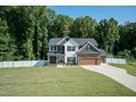 Two-story house with stone accents, a large yard, and a two-car garage at 159 Shady Oaks Dr, Benson, NC 27504