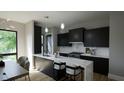 Modern kitchen with marble countertops and black cabinetry at 512 Gordon St # 1102, Durham, NC 27701