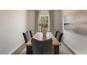 Formal dining room with wood table and six chairs, large window and artwork at 6421 Alfalfa Ln, Wake Forest, NC 27587