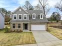 Inviting two-story home with gray siding, brick facade, and a welcoming front entrance at 1208 Randwick Valley Ct, Zebulon, NC 27597