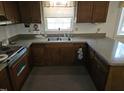 A galley-style kitchen with wood cabinets and speckled countertops at 2501 Landis Dr, Durham, NC 27705