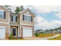 Tan townhome with white garage door, stone accents, and a curved walkway at 2005 Frost Dr, Haw River, NC 27258