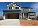 Two-story home with gray siding, stone accents, and a two-car garage at 499 Glenkirk Pl # 101, Garner, NC 27529