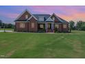 Brick home with a large front yard at dusk at 1468 Lassiter Pond Rd, Four Oaks, NC 27524