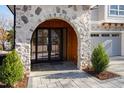 Stone arch entryway with wood accents and black double doors at 1610 Carson St, Raleigh, NC 27608