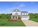 Two-story house with white siding, stone accents, and a two-car garage at 215 Kitty Branch Way, Smithfield, NC 27577