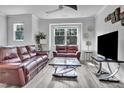 Relaxing living room featuring leather sofas, a coffee table, and a large TV at 5436 Crescent Square St, Raleigh, NC 27616